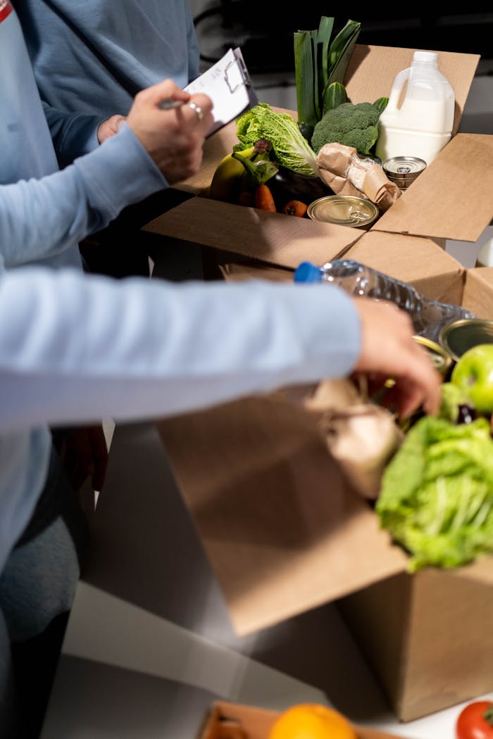 hero-contact Volunteers organize fresh produce and canned goods for community distribution indoors.