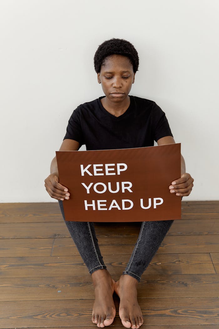 about-02 Black woman holding an empowering sign with a positive message.