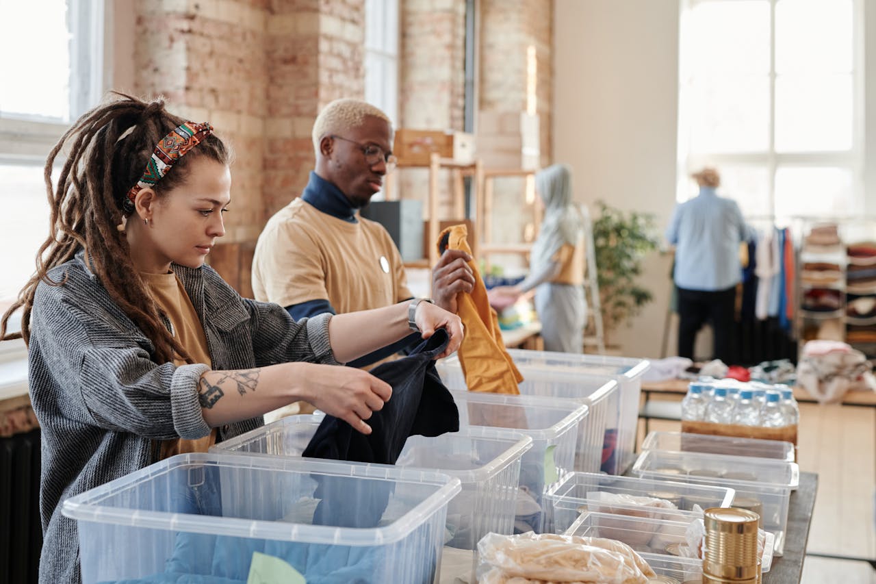 hero-homepage Volunteers organize donated clothing at a donation center, fostering community support and sustainability.
